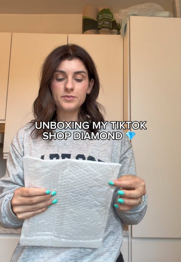 TikTok by @chickenfingerqueen: holding a white padded mailer, captioned Unboxing My TikTok Shop Diamond